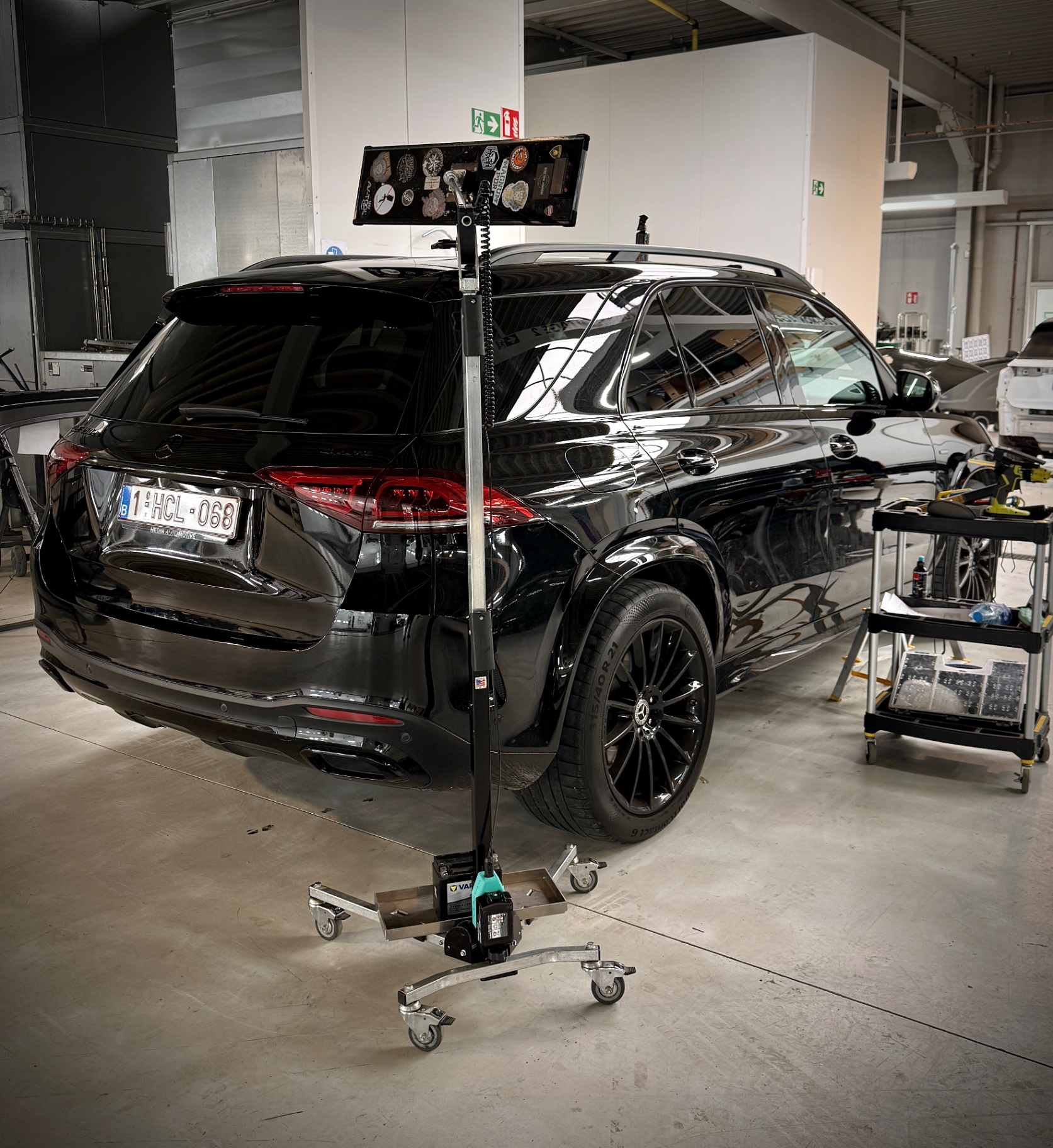 SUV negru cu panoul de lumină PDR montat pe caroserie, într-un atelier european